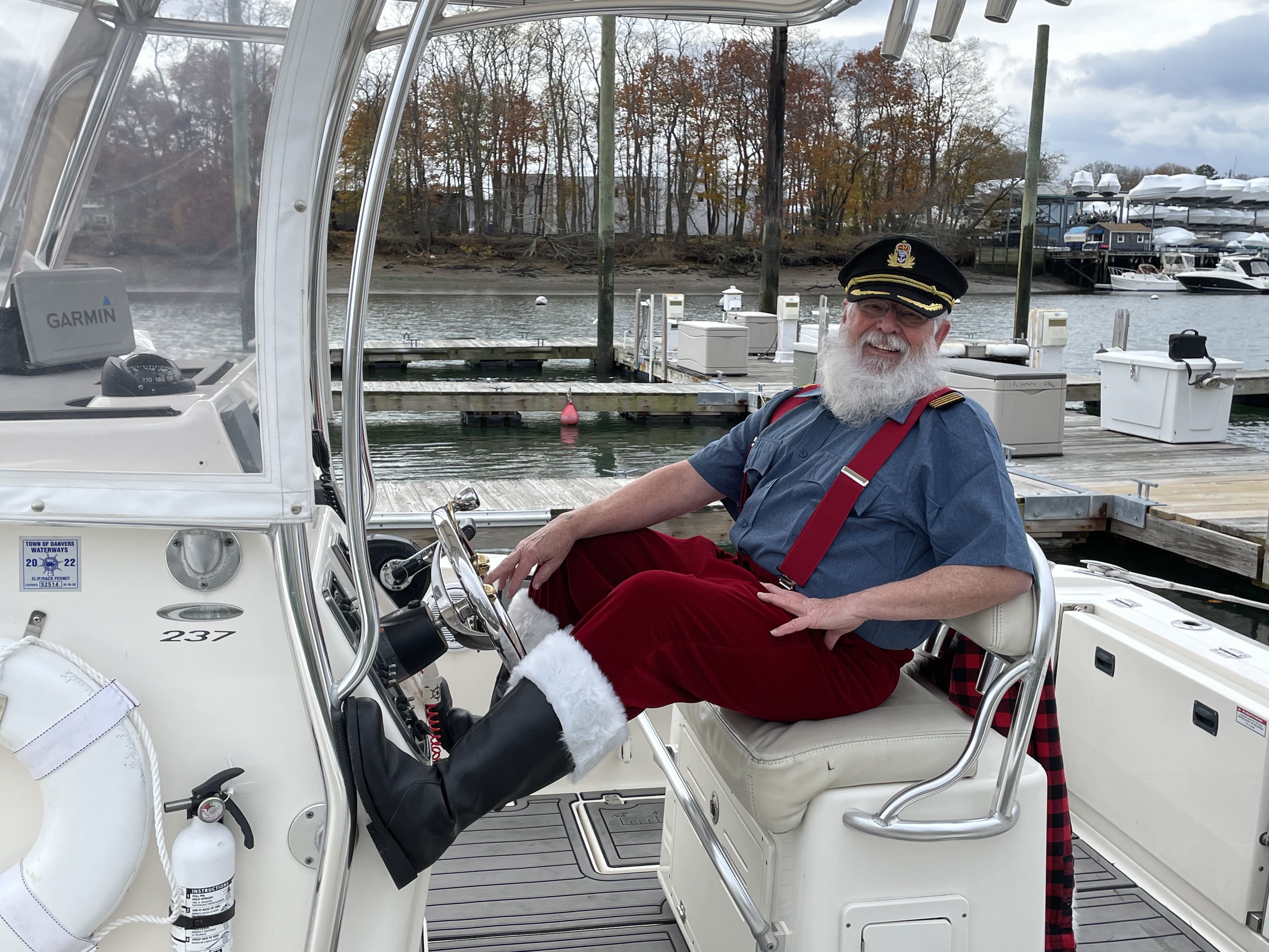 Santa Ricky bringing cheer at a summer event, bright daylight and festive colors.